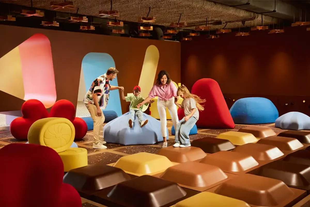 A family playing on a chocolate-inspired exhibit